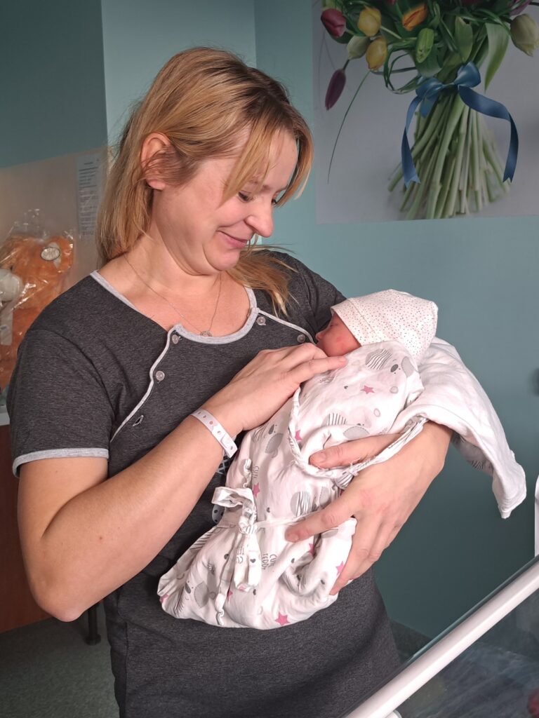 Mama trzyma na rękach noworodka